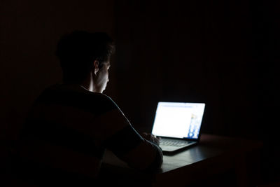 Man using mobile phone in darkroom