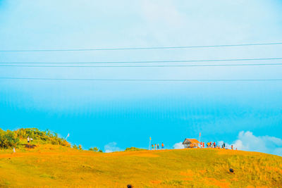 People on landscape against blue sky