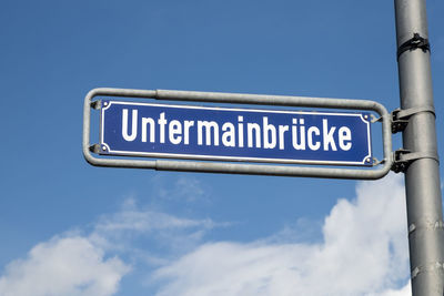 Low angle view of road sign against blue sky