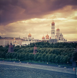 Buildings in city against cloudy sky