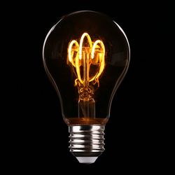 Close-up of illuminated light bulb against black background