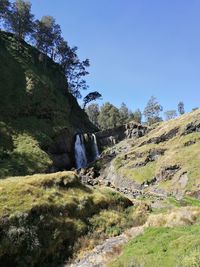 Scenic view of waterfall against sky