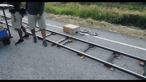 Low section of people walking on railroad track