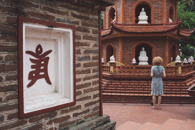 Rear view full length of woman standing outside temple