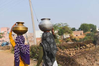 Two women carrying water pot on their head in haryana