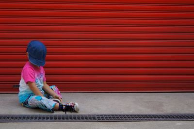 Full length of woman sitting on wall