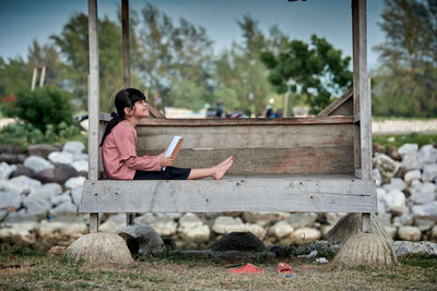 Young woman sitting on bench at park