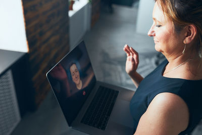 Businesswoman having business video call on laptop in office. mature busy woman working remotely