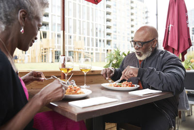 Couple having food together while sitting at restaurant