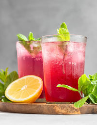 Cold sparkling hibiscus tea with lemon, mint and ice in glasses. summer drink, lemonade.