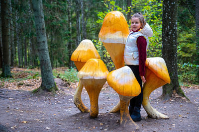 Full length of woman with pumpkins in forest