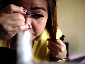 Close-up of woman applying make-up