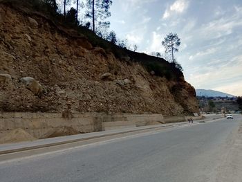 Empty road by mountain against sky