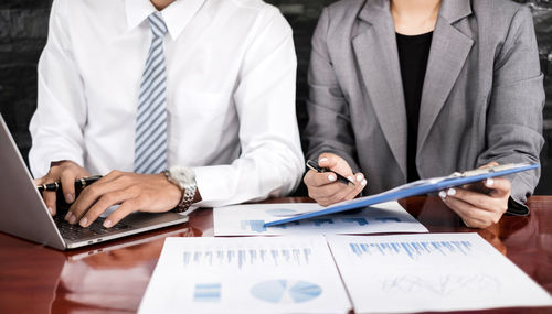 Midsection of businessman working at table
