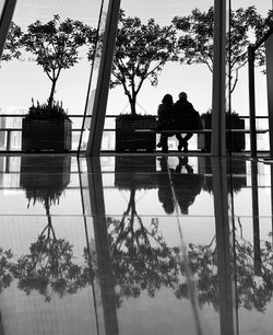 Rear view of people on lake against sky