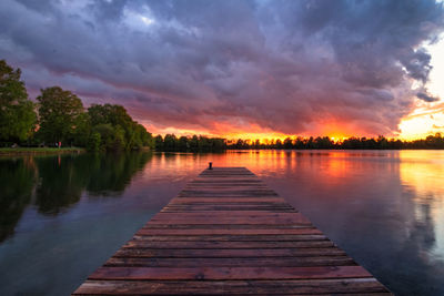 Pier over lake against sky during sunset