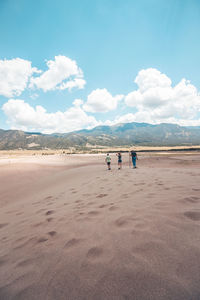 People standing on desert against sky