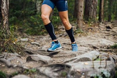 Low section of woman walking in forest