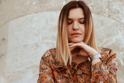 Low angle view of beautiful young woman against wall