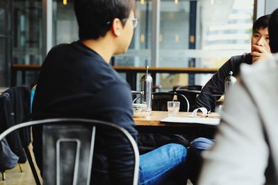 Rear view of man sitting at restaurant