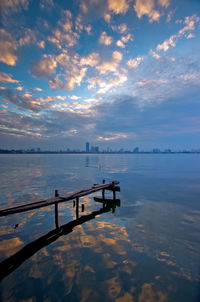 Pier over sea against sky during sunset