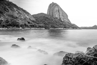 Scenic view of sea and mountains against clear sky