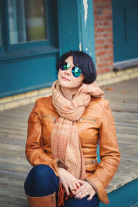 Woman wearing sunglasses sitting outdoors