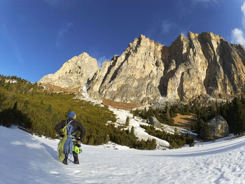 Rear view of man with climbing equipment against mountain 