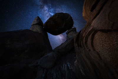 Low angle view of rock formation against sky at night