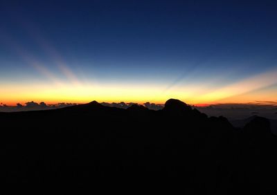 Scenic view of silhouette mountains against sky during sunset