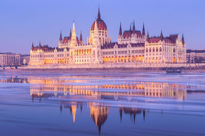 Reflection of building in city at dusk