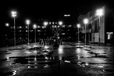 Illuminated city street during rainy season at night