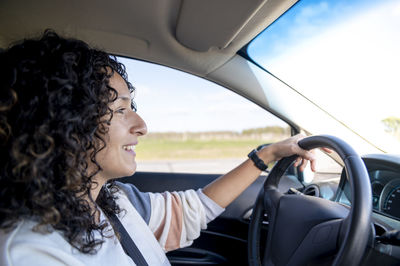 Side view of woman sitting in car