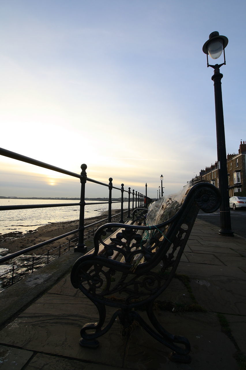 STREET LIGHTS ON PIER BY SEA AGAINST SKY