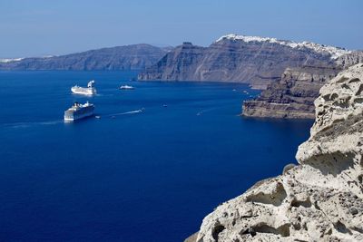 Scenic view of sea and rock formations against blue sky