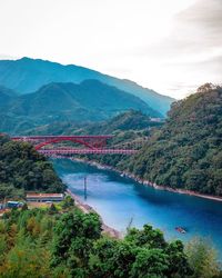 Scenic view of river by mountains against sky