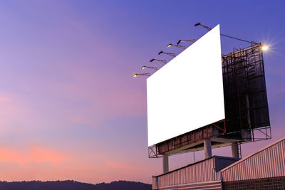 Low angle view of blank billboard against sky during sunset