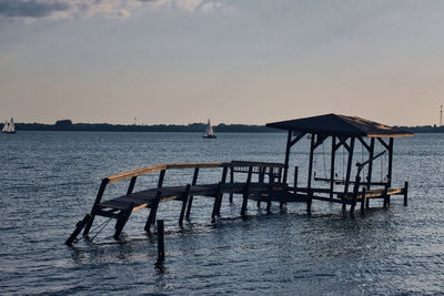 Pier over sea against sky during sunset