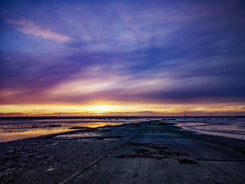 Scenic view of beach against sky during sunset