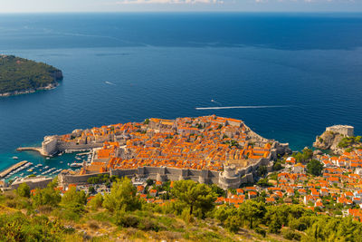 High angle view of townscape by sea against sky