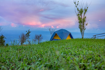 Tent on field against sky during sunset