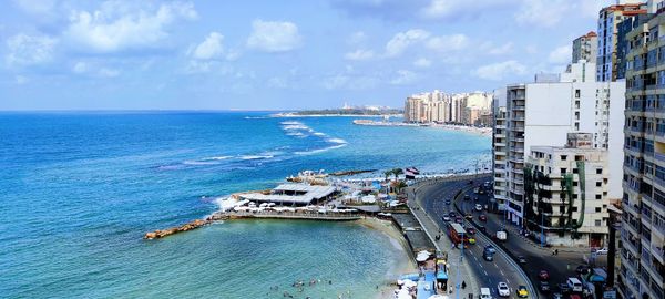 High angle view of buildings by sea against sky