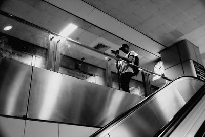 Low angle view of man photographing at subway station