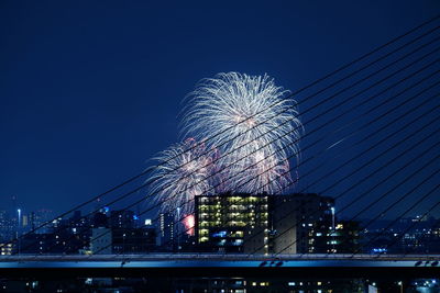 Low angle view of fireworks against sky at night