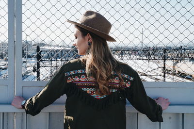 Young woman standing against built structure