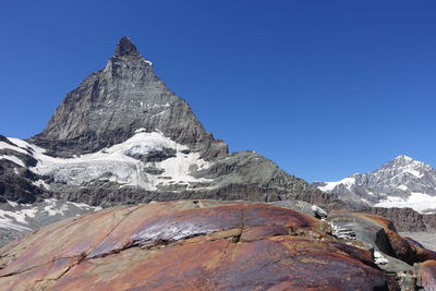 Scenic view of snowcapped mountains against clear blue sky