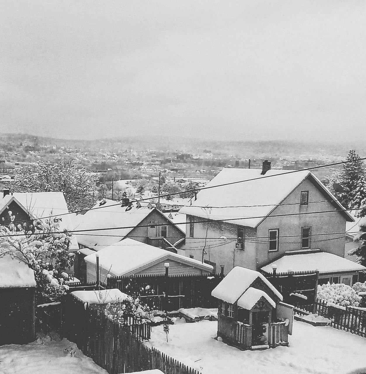 building exterior, architecture, built structure, house, residential structure, residential building, roof, clear sky, residential district, winter, high angle view, cityscape, copy space, city, sky, snow, cold temperature, town, crowded, townscape