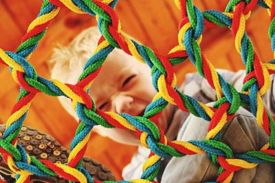 Boy seen through multi colored netting