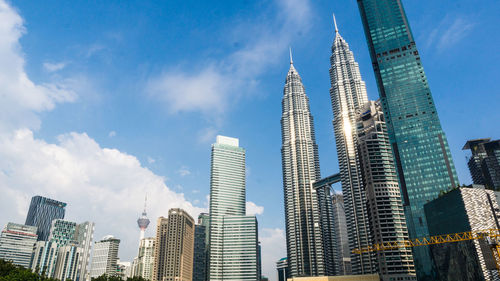 Low angle view of buildings against cloudy sky