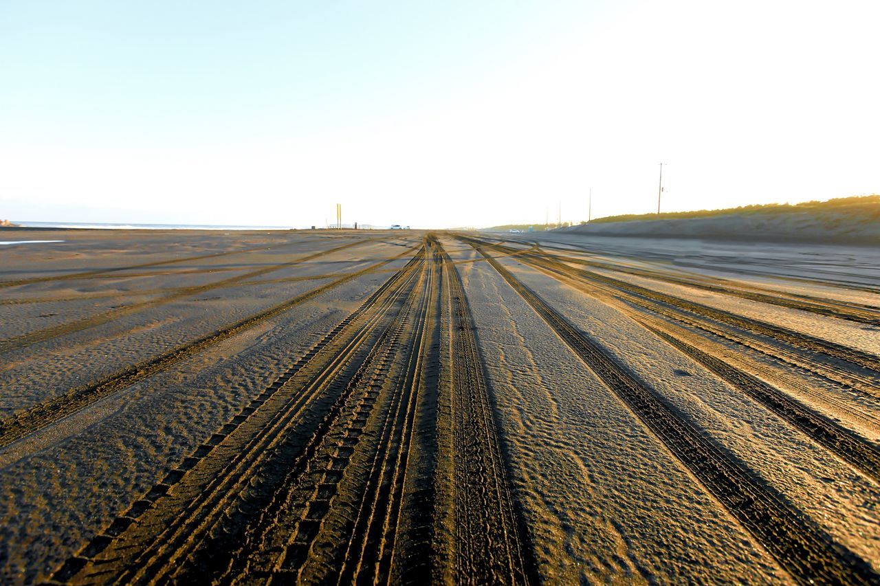 the way forward, clear sky, diminishing perspective, transportation, vanishing point, railroad track, copy space, landscape, sky, road, tire track, long, rail transportation, tranquility, outdoors, tranquil scene, surface level, no people, day, nature